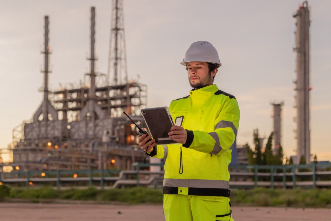 Techniker prüft mit Tablet eine Energieanlage vor Ort