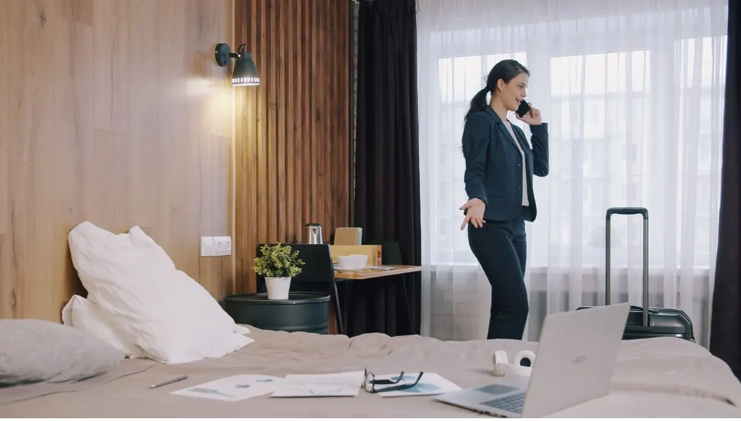 Geschäftsreisende telefoniert in einem Hotelzimmer